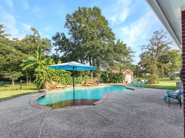 view of pool with a patio, an outbuilding, and a yard