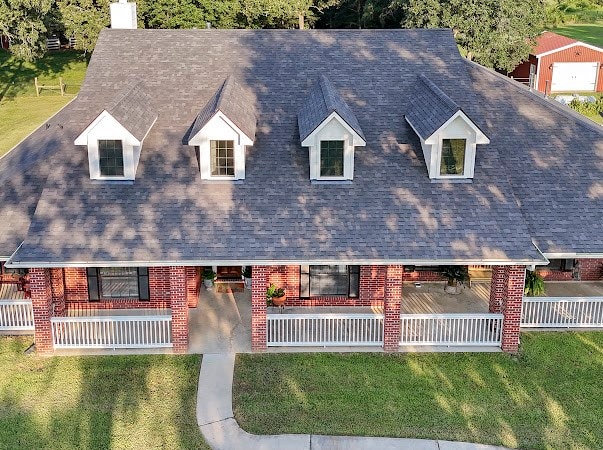 view of front of home featuring a front lawn, covered porch, and a garage