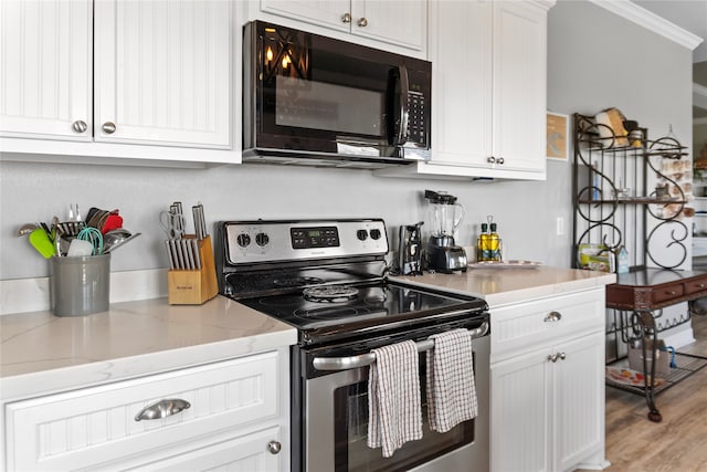 kitchen featuring light hardwood / wood-style flooring, white cabinetry, electric range, and light stone counters