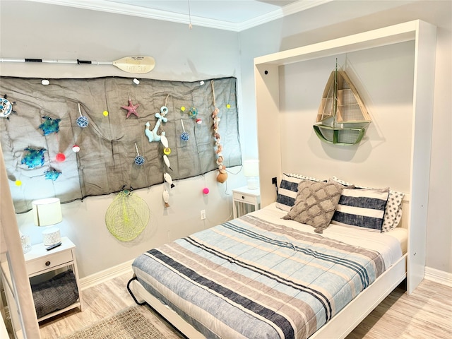 bedroom featuring crown molding and light hardwood / wood-style floors