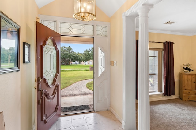 foyer with vaulted ceiling, a chandelier, light tile patterned floors, and ornate columns