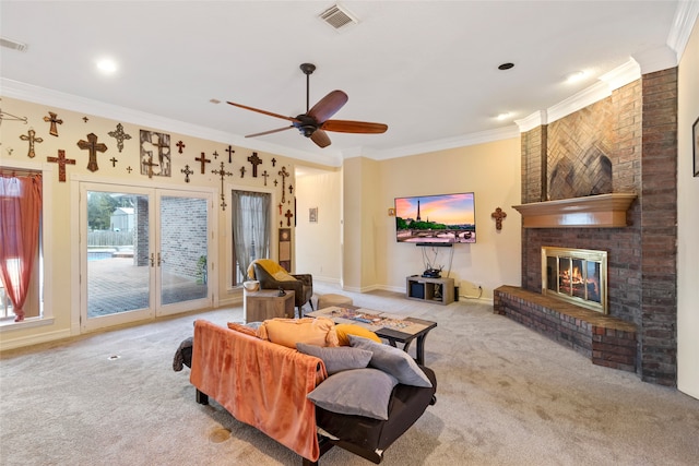 carpeted living room with ceiling fan, crown molding, brick wall, and a brick fireplace