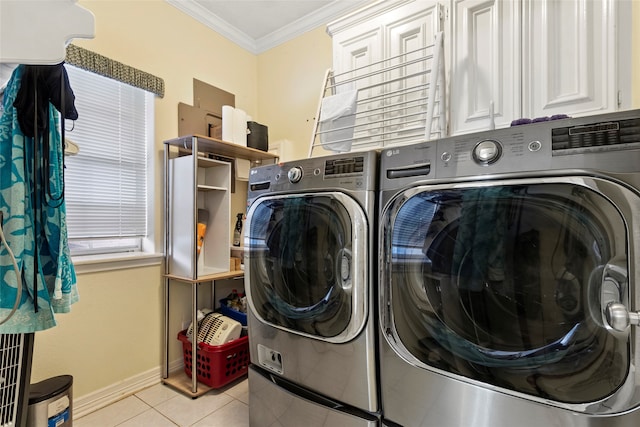 washroom with ornamental molding, washing machine and clothes dryer, and light tile patterned floors