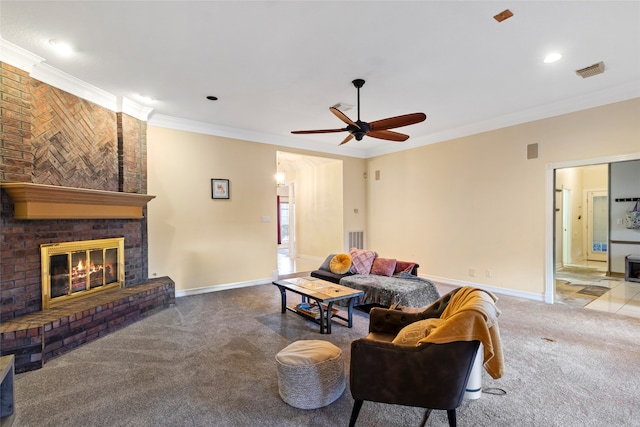 living room featuring ceiling fan, a fireplace, carpet, and crown molding