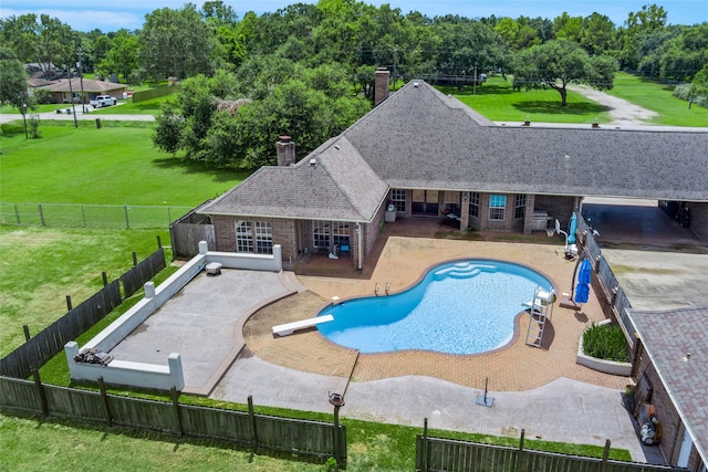 view of pool featuring a patio, a yard, and a diving board