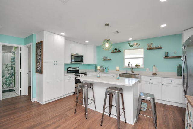 kitchen with white cabinets, appliances with stainless steel finishes, hanging light fixtures, and sink