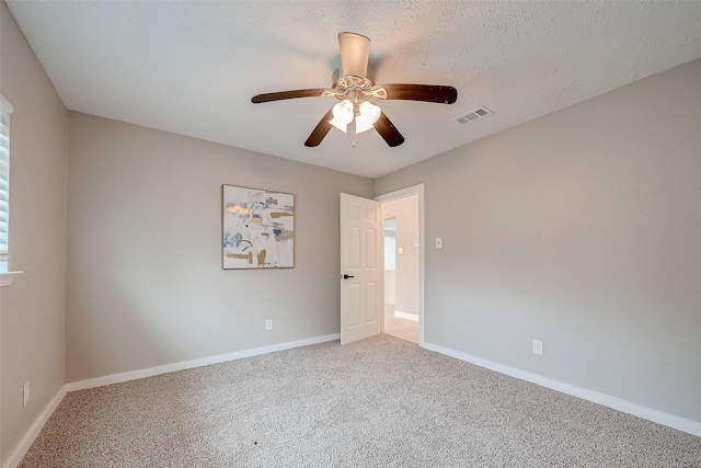 unfurnished room featuring ceiling fan, a textured ceiling, and carpet floors