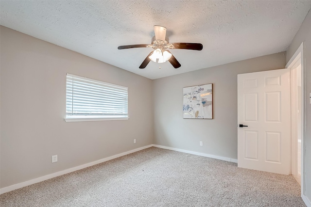 unfurnished room featuring a textured ceiling, carpet floors, and ceiling fan