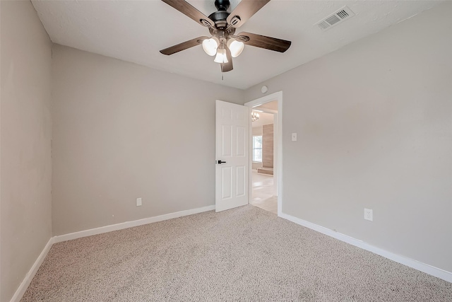 spare room with ceiling fan and carpet