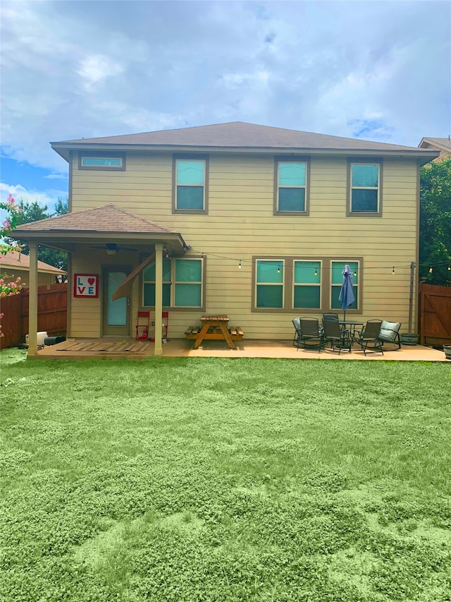 back of property with a yard and a patio