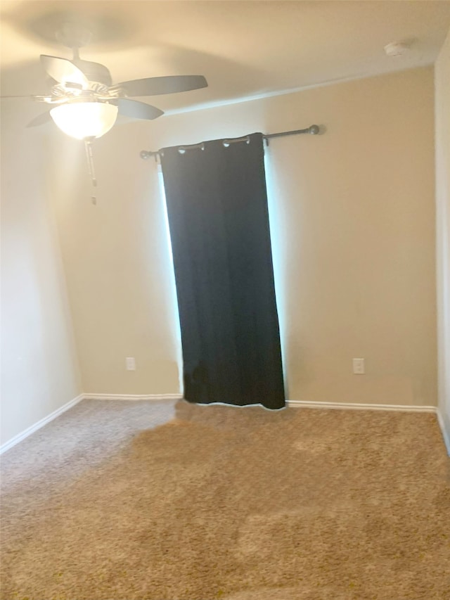 unfurnished room with ceiling fan and carpet