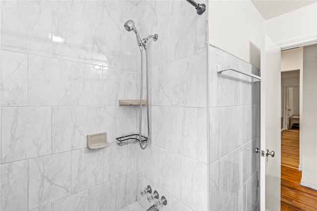 bathroom with hardwood / wood-style floors and tiled shower / bath combo