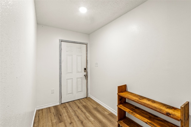 foyer with light hardwood / wood-style flooring and a textured ceiling