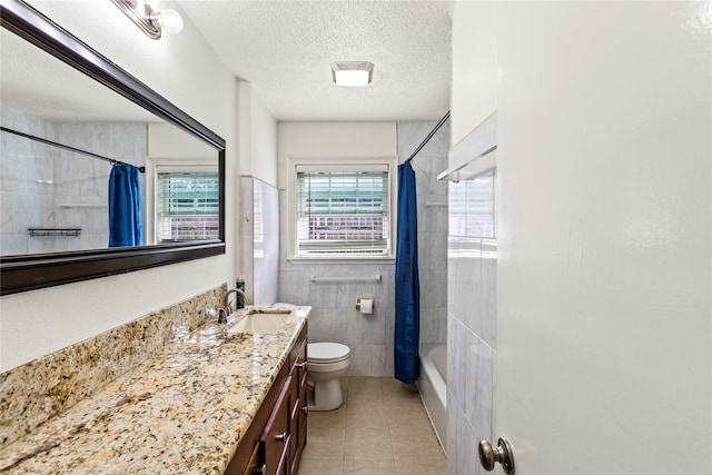 full bathroom with a textured ceiling, toilet, tile patterned flooring, shower / tub combo with curtain, and vanity