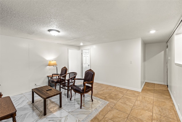 living area with light tile patterned flooring and a textured ceiling