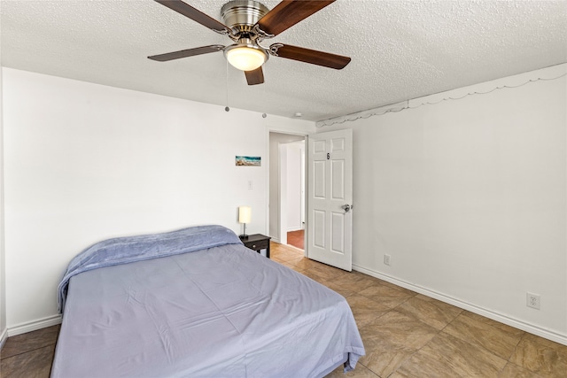 tiled bedroom featuring a textured ceiling and ceiling fan