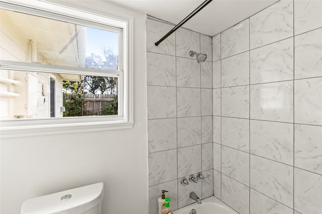 bathroom with tiled shower / bath and toilet