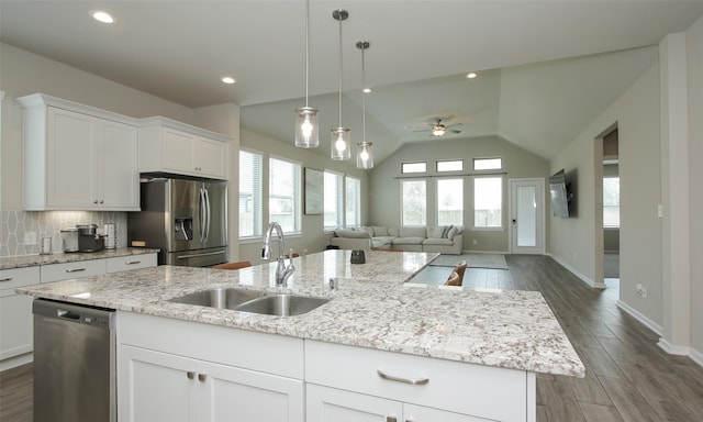 kitchen featuring decorative backsplash, ceiling fan, an island with sink, stainless steel appliances, and sink