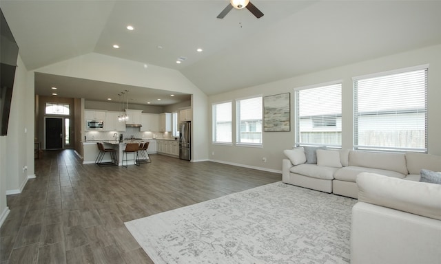 living room with ceiling fan, wood-type flooring, and lofted ceiling