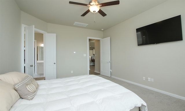 carpeted bedroom with connected bathroom and ceiling fan