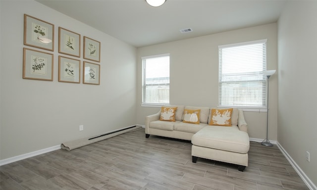 living area featuring a baseboard radiator and plenty of natural light