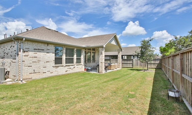 rear view of house with a lawn, a patio area, and central air condition unit