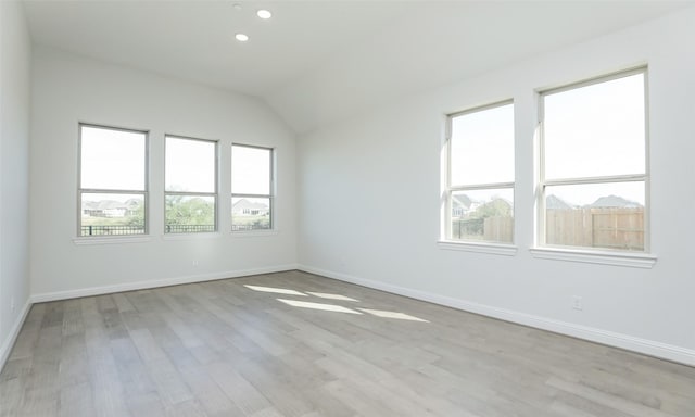 unfurnished room with light wood-type flooring and vaulted ceiling