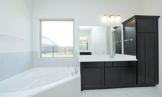 bathroom featuring vanity and tiled bath