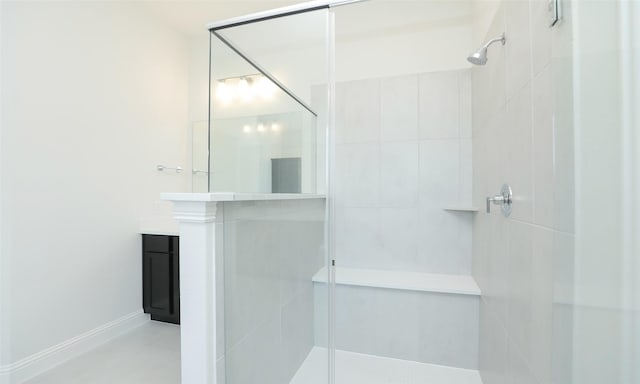 bathroom with a tile shower and vanity