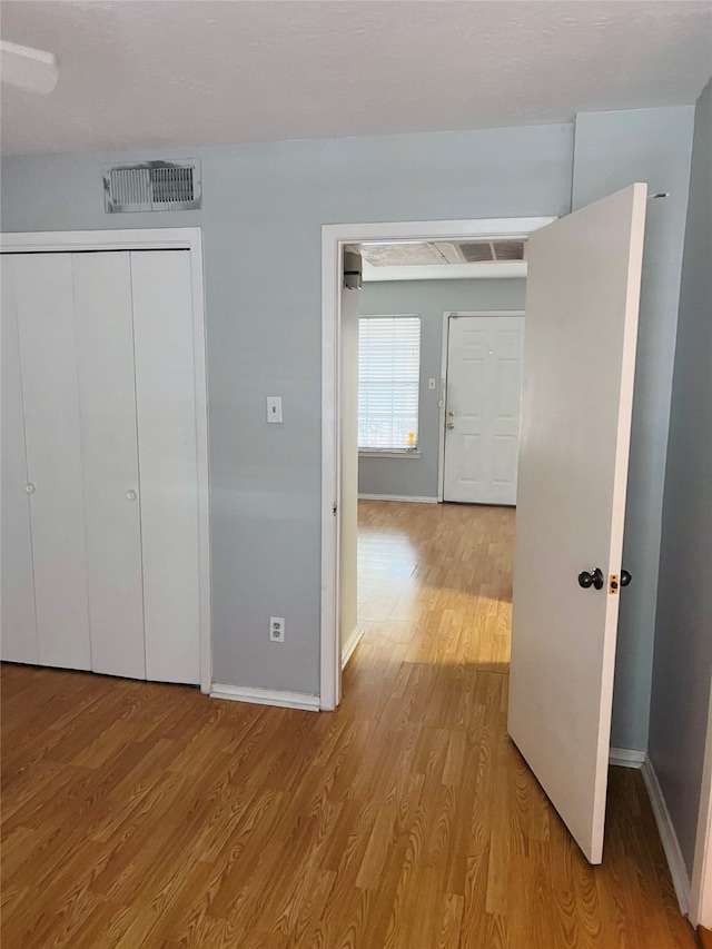 unfurnished bedroom featuring light hardwood / wood-style floors and a closet