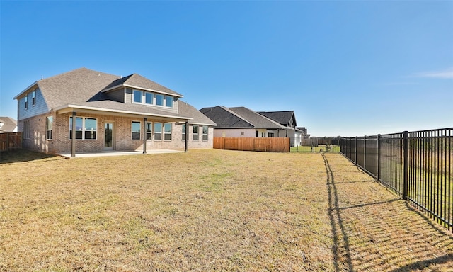 back of house featuring a lawn and a patio