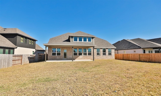 back of property with a yard and a patio