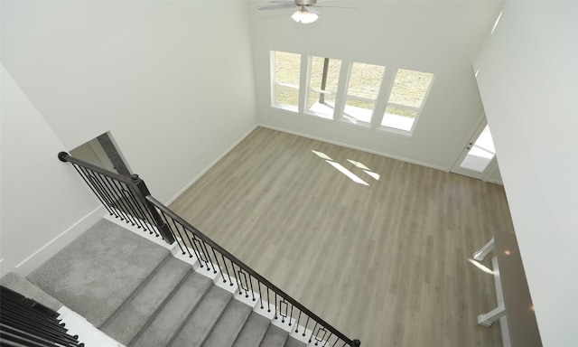 stairs featuring ceiling fan and wood-type flooring