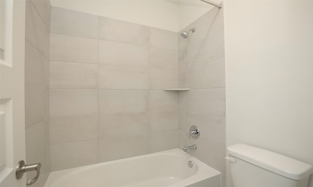 bathroom with tiled shower / bath combo and toilet