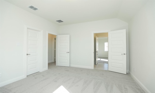 unfurnished bedroom featuring light carpet