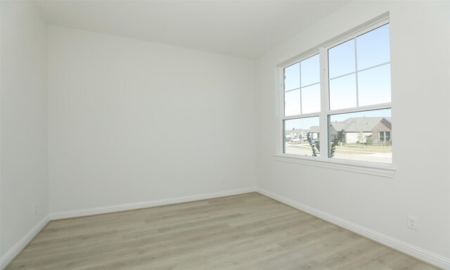 spare room featuring plenty of natural light and light hardwood / wood-style floors