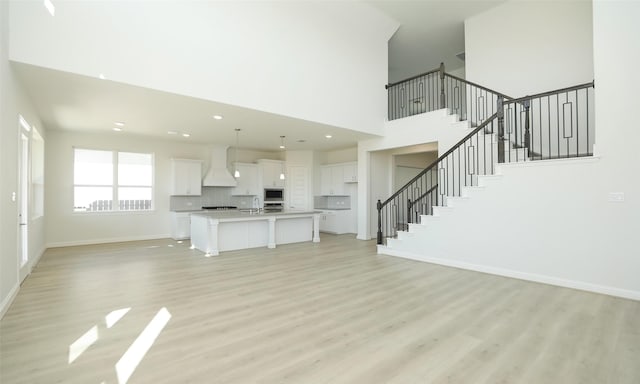 unfurnished living room featuring light hardwood / wood-style flooring and sink