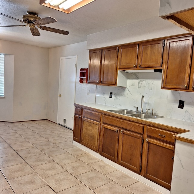 kitchen featuring tasteful backsplash, ceiling fan, sink, and light tile patterned flooring