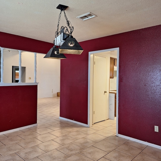 unfurnished room featuring light tile patterned flooring and a textured ceiling