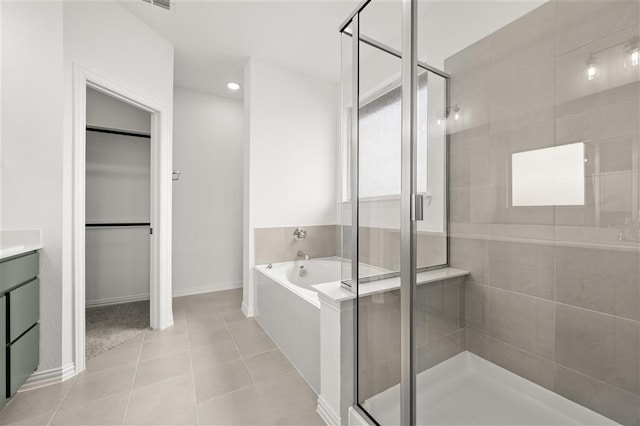 bathroom with tile patterned flooring, vanity, and separate shower and tub