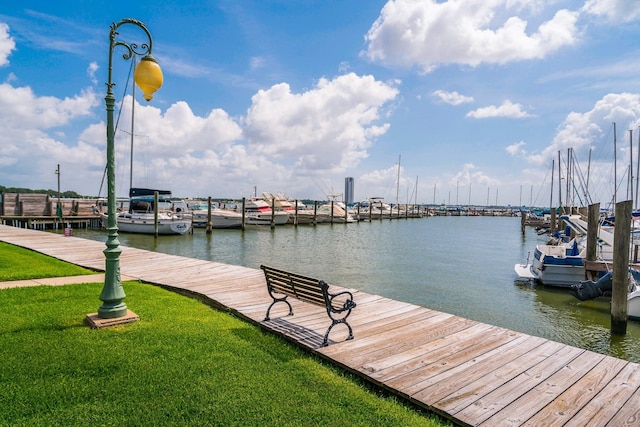 dock area with a lawn and a water view