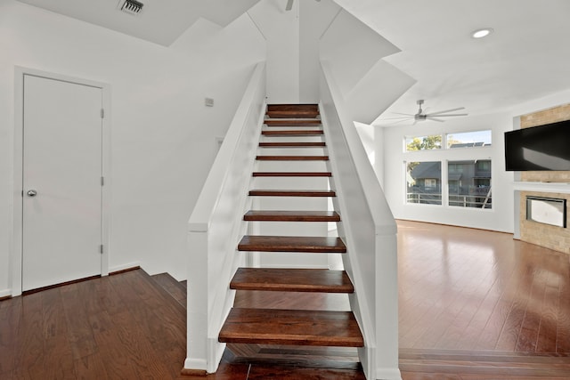 stairs featuring ceiling fan and wood-type flooring