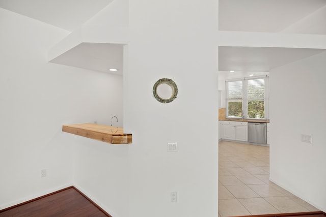 details with stainless steel dishwasher and hardwood / wood-style flooring