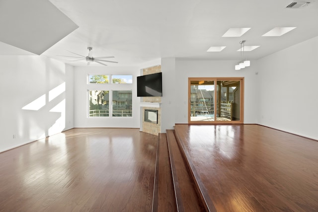 unfurnished living room with ceiling fan, wood-type flooring, and plenty of natural light