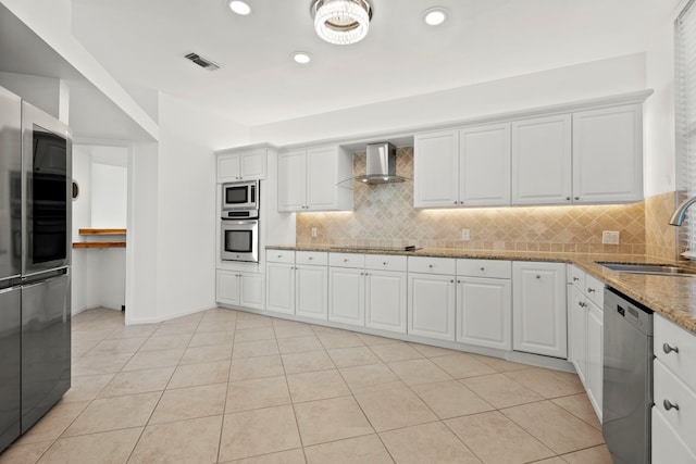 kitchen with wall chimney exhaust hood, sink, appliances with stainless steel finishes, and white cabinets