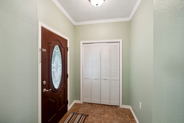 tiled entrance foyer with a textured ceiling and crown molding