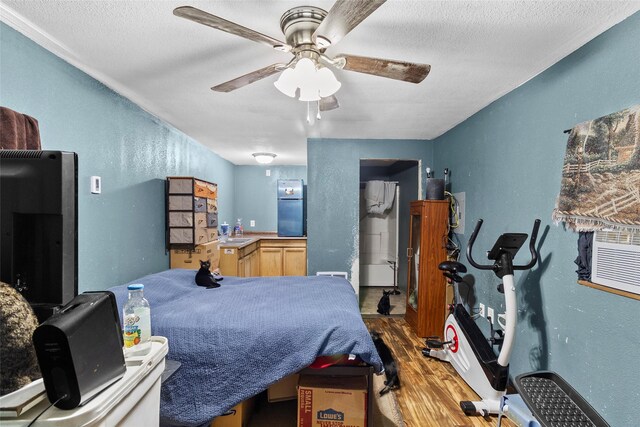 bedroom featuring a textured ceiling, stainless steel refrigerator, hardwood / wood-style floors, and ceiling fan