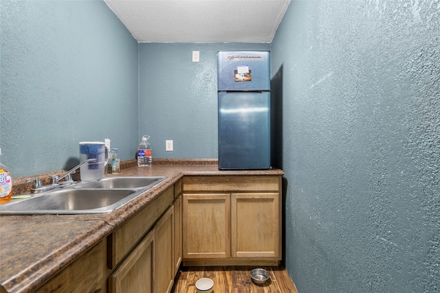 kitchen featuring sink, hardwood / wood-style flooring, and a textured ceiling