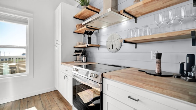 kitchen featuring island range hood, white cabinetry, light countertops, stainless steel electric stove, and open shelves