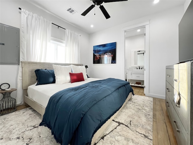 bedroom featuring ensuite bath, light wood-type flooring, and ceiling fan